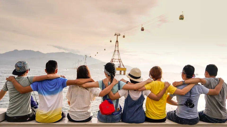 Grupo de jóvenes de espaldas con los brazos alrededor de los hombros