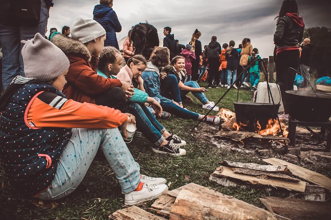 Grupo de jóvenes reunidos alrededor de una fogata
